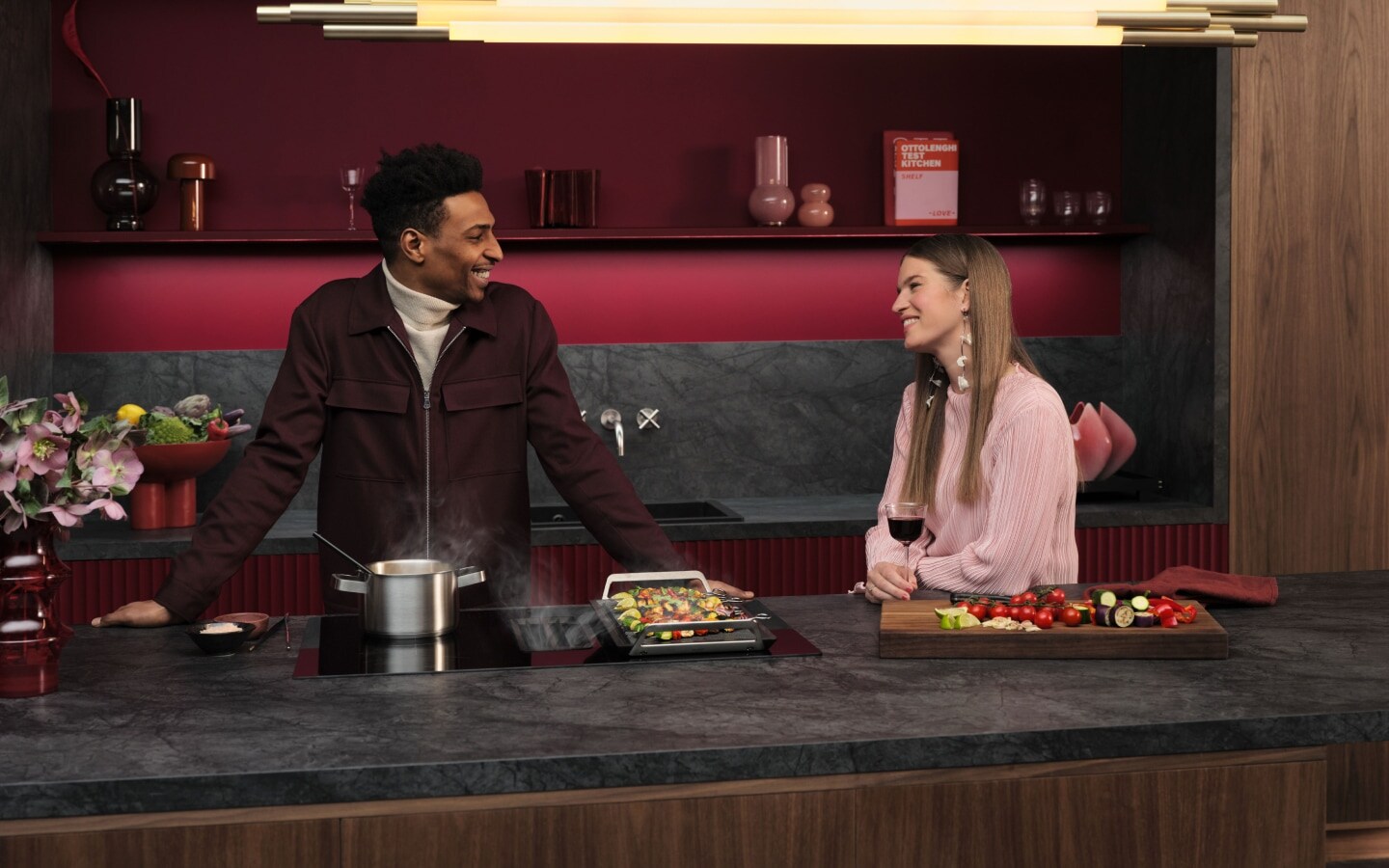 Homme et femme debout dans une cuisine en train de cuisiner.