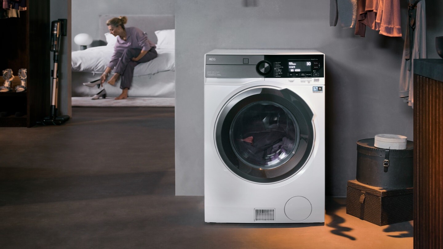Lave-linge séchant dans une pièce avec femme en arrière-plan