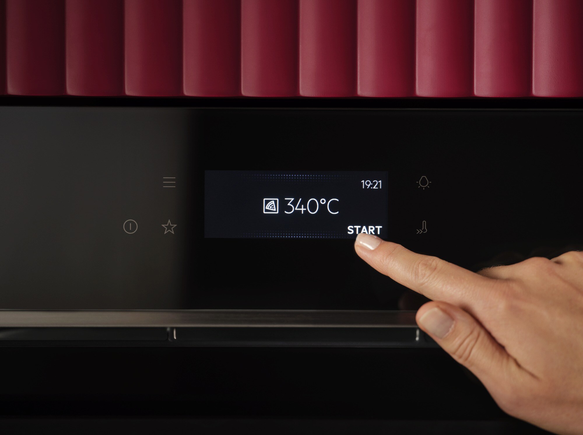 Personne touchant l’option de démarrage sur l’écran d’un four.